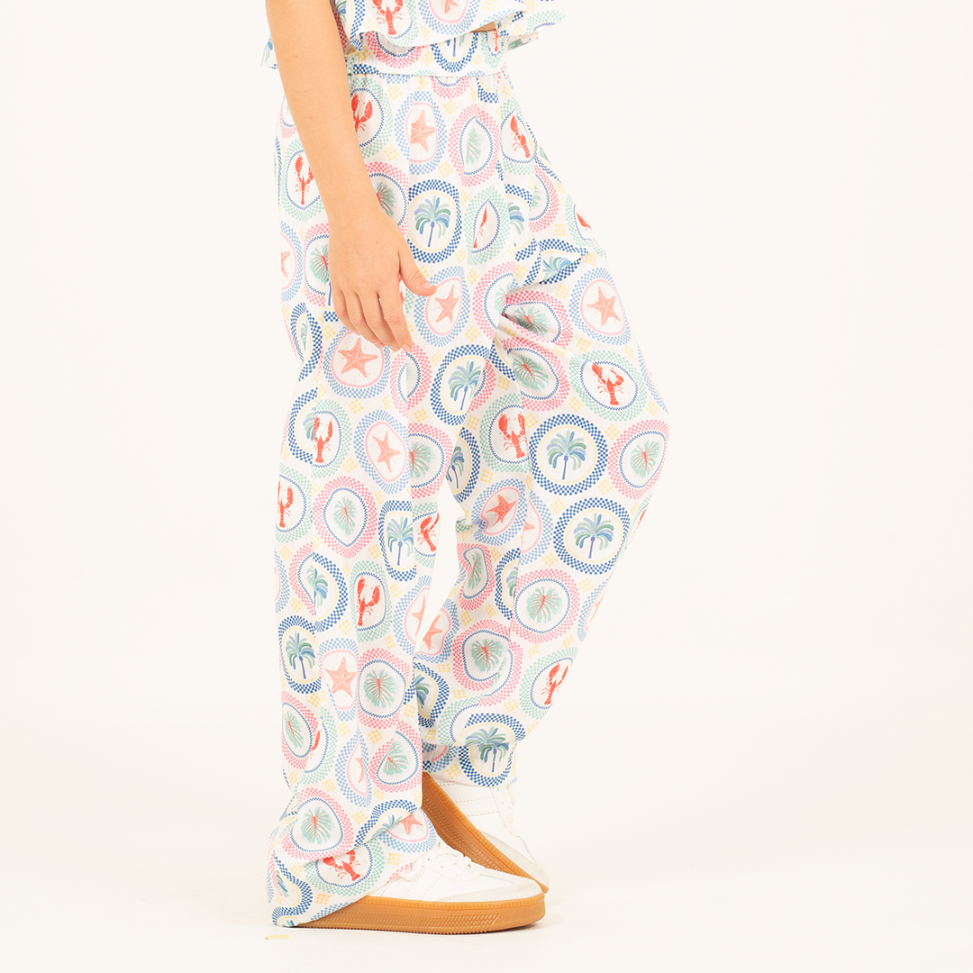 PANTALÓN PARA NIÑA CON ESTAMPADO TROPICAL Y SILUETA AMPLIA